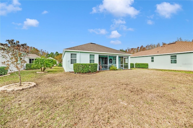 rear view of property featuring a lawn and a sunroom