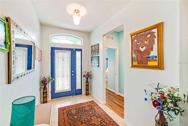 tiled foyer featuring a textured ceiling