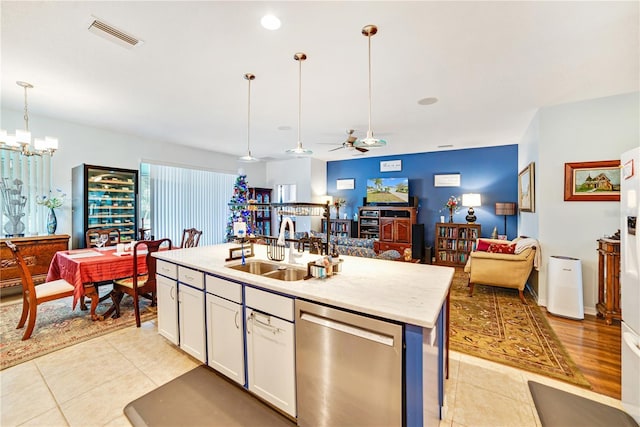 kitchen with pendant lighting, a kitchen island with sink, white cabinets, ceiling fan with notable chandelier, and stainless steel dishwasher