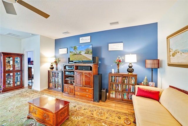 living room featuring light hardwood / wood-style flooring and ceiling fan