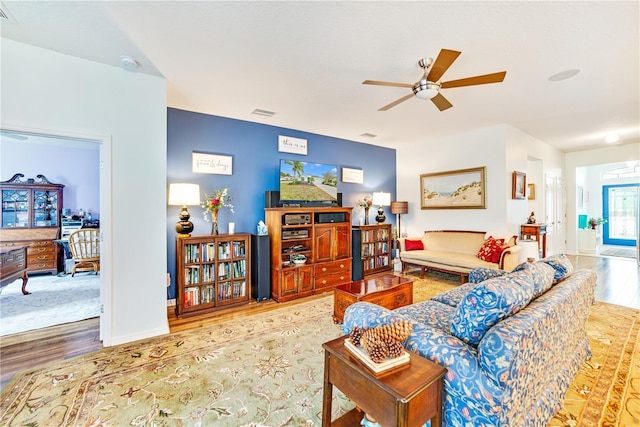 living room featuring ceiling fan and hardwood / wood-style flooring