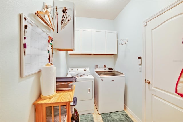 washroom with washing machine and clothes dryer and cabinets