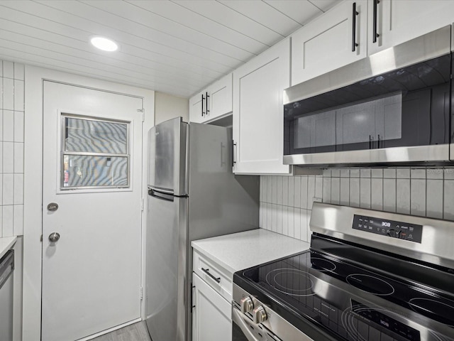 kitchen with white cabinets, appliances with stainless steel finishes, and light hardwood / wood-style floors