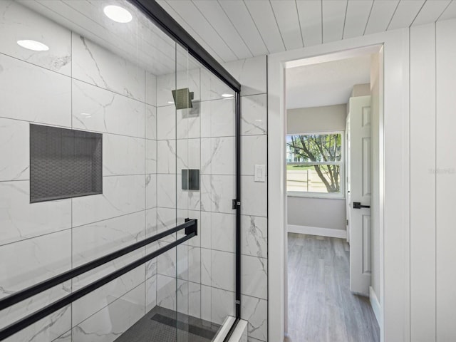 bathroom featuring wood-type flooring and a shower with shower door