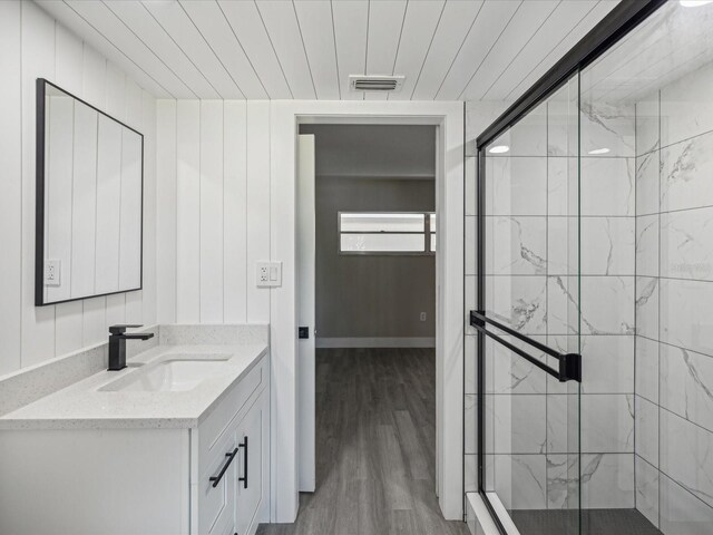 bathroom with an enclosed shower, hardwood / wood-style flooring, and vanity