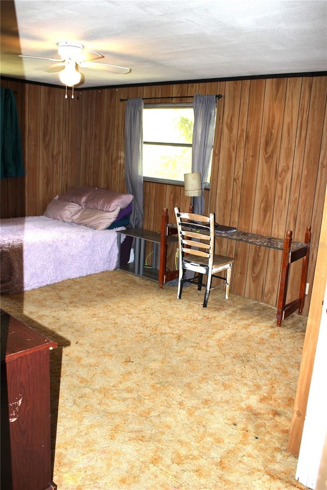 bedroom featuring carpet floors, wood walls, and ceiling fan