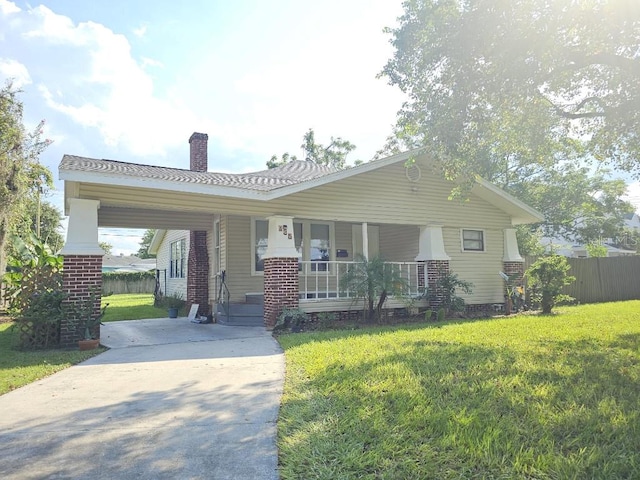 ranch-style house with a carport, a porch, and a front lawn