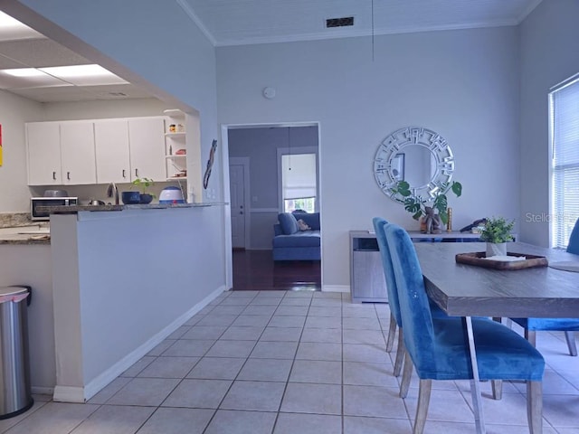 dining space with ornamental molding, plenty of natural light, and light tile patterned flooring