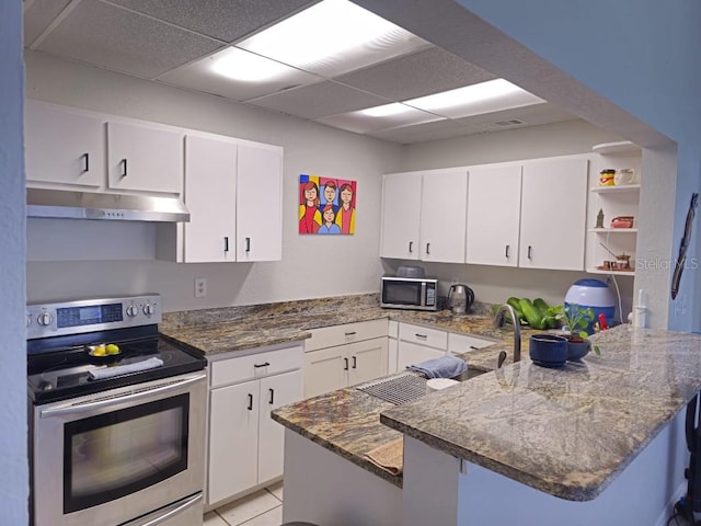 kitchen with kitchen peninsula, white cabinetry, light tile patterned floors, and stainless steel appliances