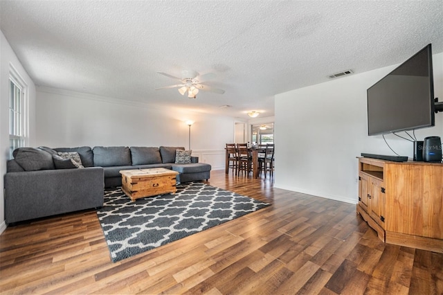 living room featuring a textured ceiling, dark hardwood / wood-style flooring, and ceiling fan