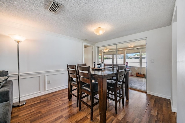 dining room featuring a textured ceiling and dark hardwood / wood-style floors