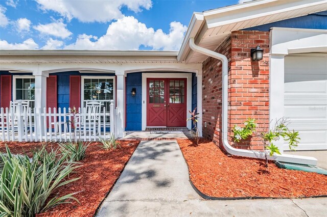 3849 Claremont Dr, New Port Richey, FL 34652 - entrance to property featuring brick siding, a garage, and a porch