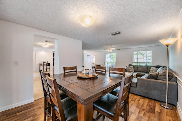 3849 Claremont Dr, New Port Richey, FL 34652 - dining area featuring wood finished floors, a textured ceiling, baseboards, and ceiling fan