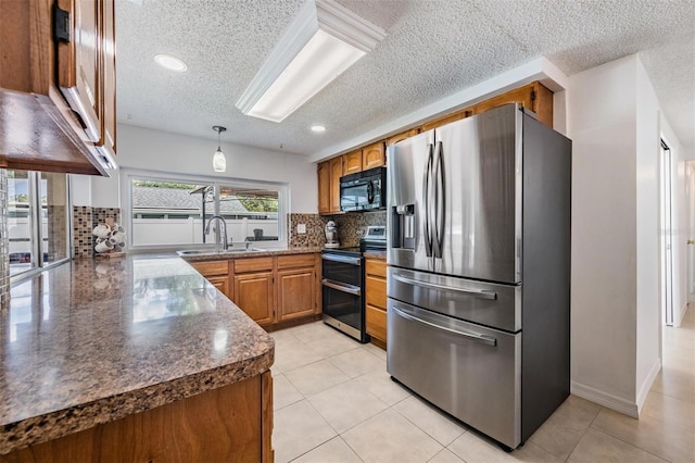 3849 Claremont Dr, New Port Richey, FL 34652 - kitchen with stainless steel appliances, brown cabinetry, a textured ceiling, dark countertops, and a sink