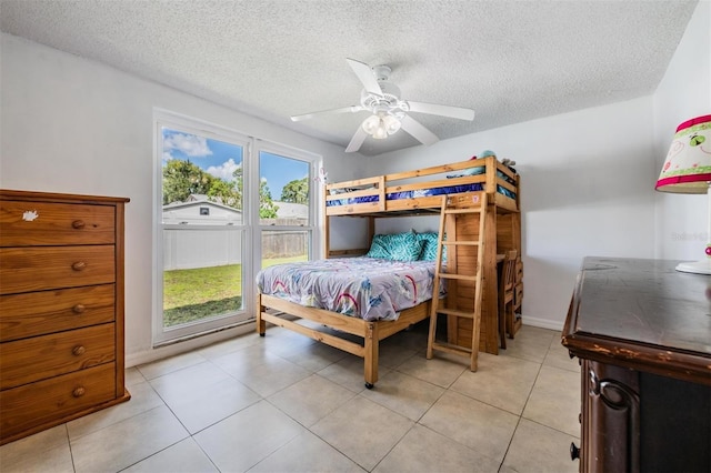 3849 Claremont Dr, New Port Richey, FL 34652 - bedroom featuring a textured ceiling, ceiling fan, light tile patterned floors, and baseboards