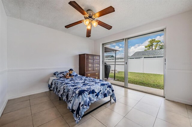 3849 Claremont Dr, New Port Richey, FL 34652 - tiled bedroom with access to outside, a textured ceiling, a ceiling fan, and baseboards