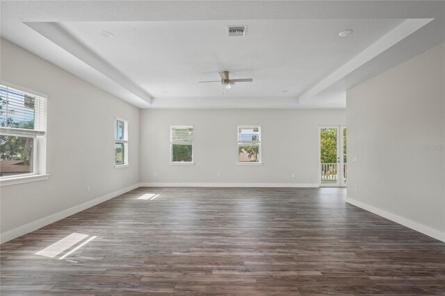 spare room with ceiling fan, plenty of natural light, and dark wood-type flooring