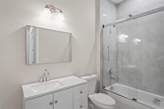 full bathroom featuring enclosed tub / shower combo, vanity, and toilet