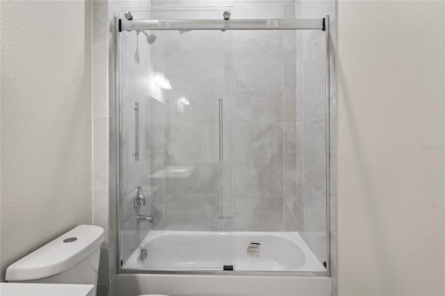 bathroom with enclosed tub / shower combo and toilet