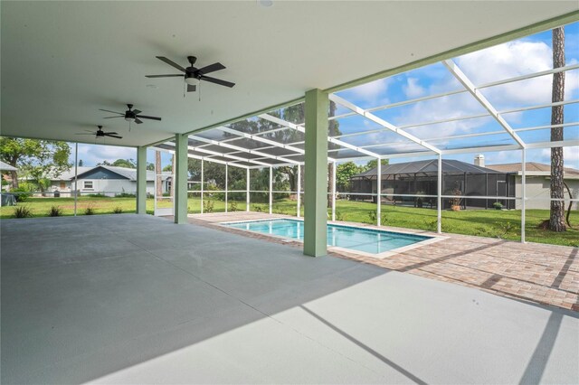 view of swimming pool with a patio, a lawn, a lanai, and ceiling fan