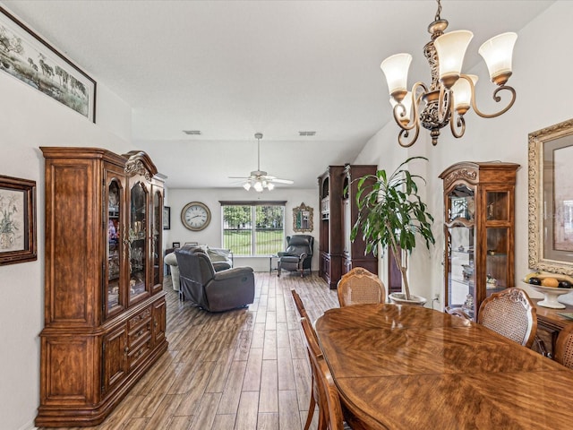 dining space featuring ceiling fan with notable chandelier and hardwood / wood-style floors