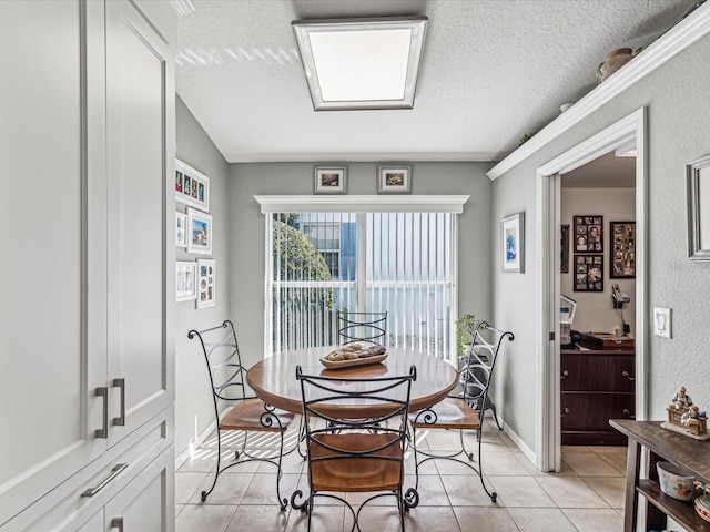 tiled dining room featuring a textured ceiling