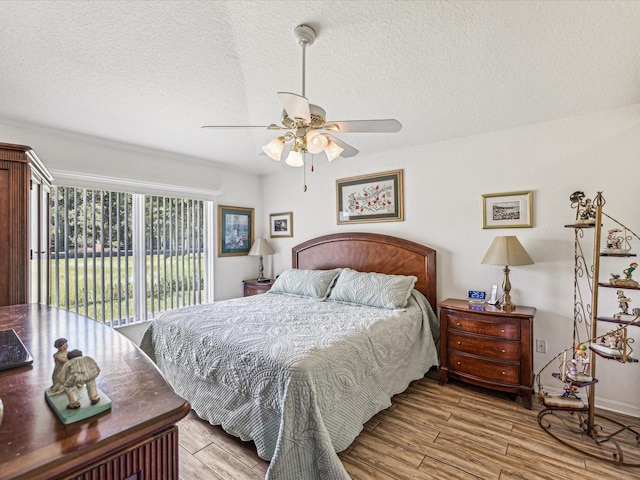 bedroom with light wood-type flooring, ceiling fan, access to outside, and a textured ceiling