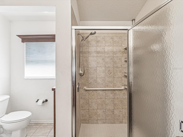 bathroom with a textured ceiling, a shower with door, tile patterned floors, and toilet