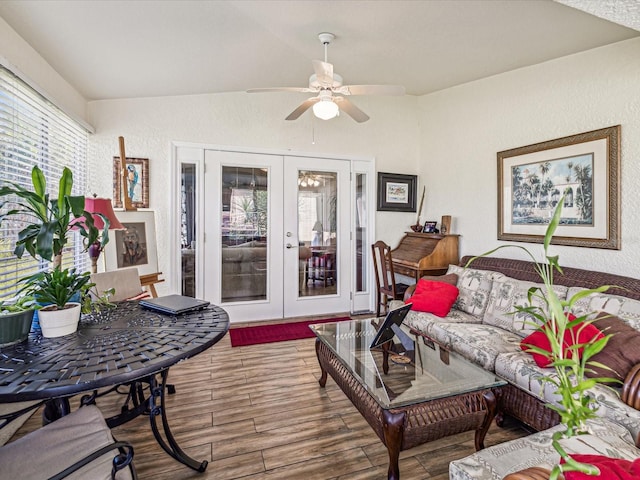 living room with lofted ceiling, ceiling fan, french doors, and hardwood / wood-style flooring