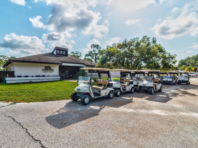 view of parking with a lawn and a carport