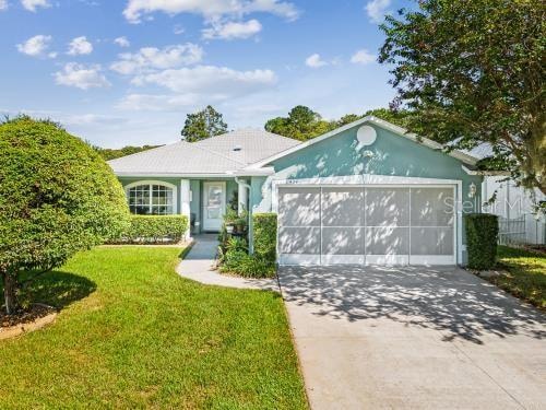 ranch-style home with a front yard and a garage