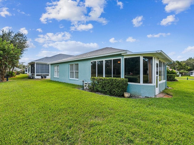 back of house with a lawn and a sunroom