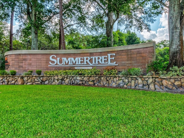 community / neighborhood sign featuring a yard