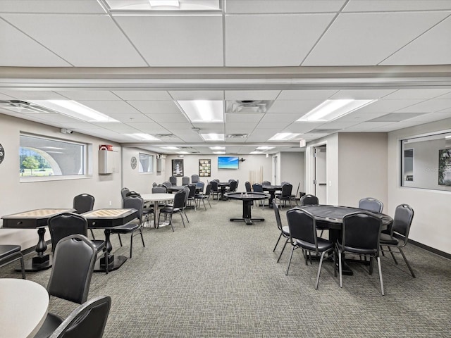 dining area featuring carpet floors and a drop ceiling