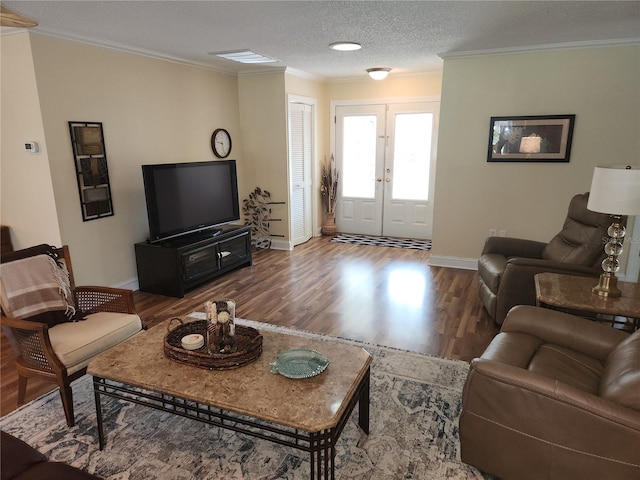 living room featuring ornamental molding, wood-type flooring, a textured ceiling, and french doors