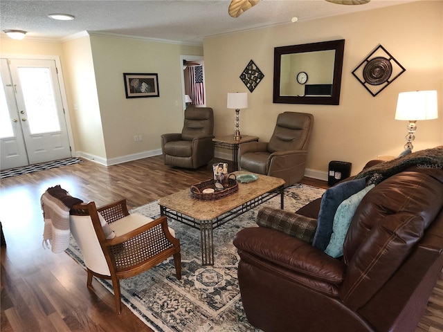 living room with a textured ceiling, crown molding, dark hardwood / wood-style floors, and french doors