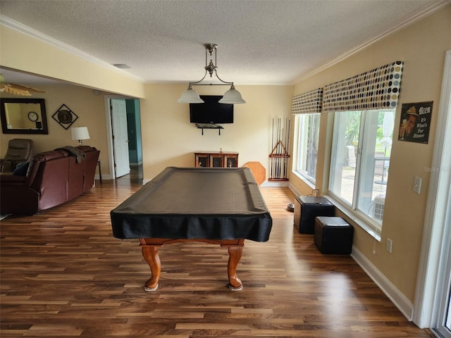 rec room with pool table, a textured ceiling, ornamental molding, and dark wood-type flooring