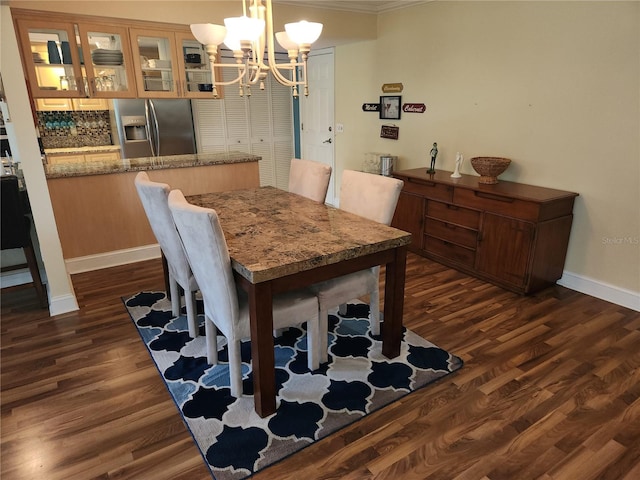 dining space featuring an inviting chandelier, dark hardwood / wood-style floors, and ornamental molding