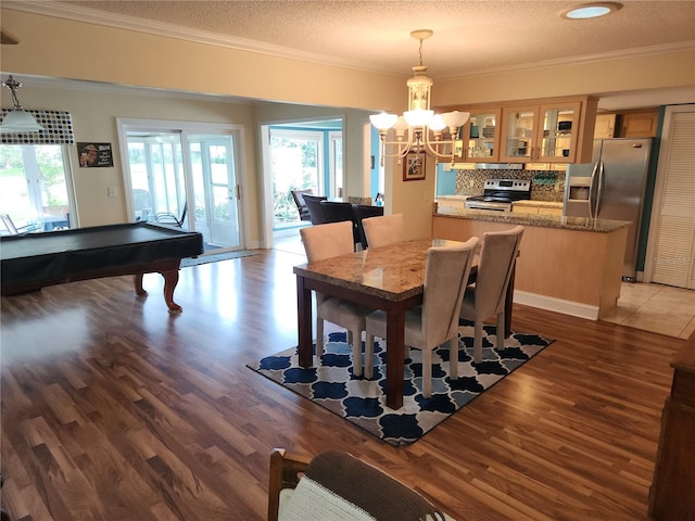 dining space featuring a textured ceiling, an inviting chandelier, billiards, crown molding, and hardwood / wood-style floors