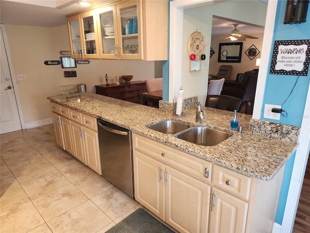 kitchen with dishwasher, light stone counters, sink, light tile patterned floors, and ceiling fan