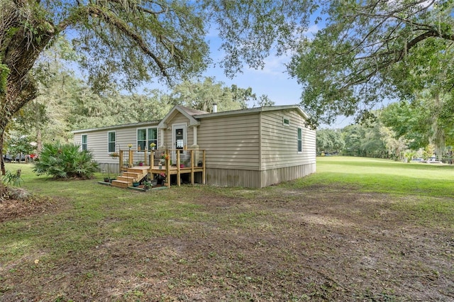 back of property with a wooden deck and a lawn