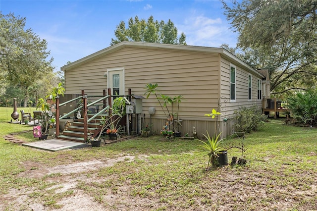 rear view of house featuring a wooden deck and a lawn