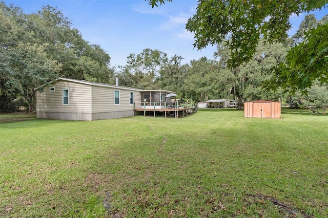 view of yard featuring a wooden deck and a shed