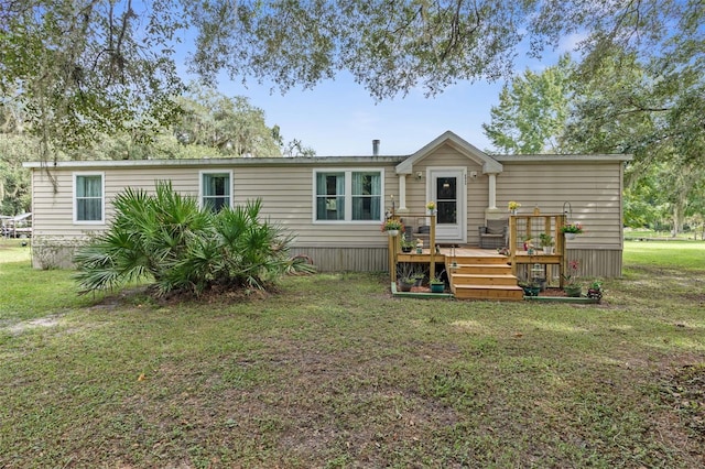 back of house featuring a wooden deck and a lawn