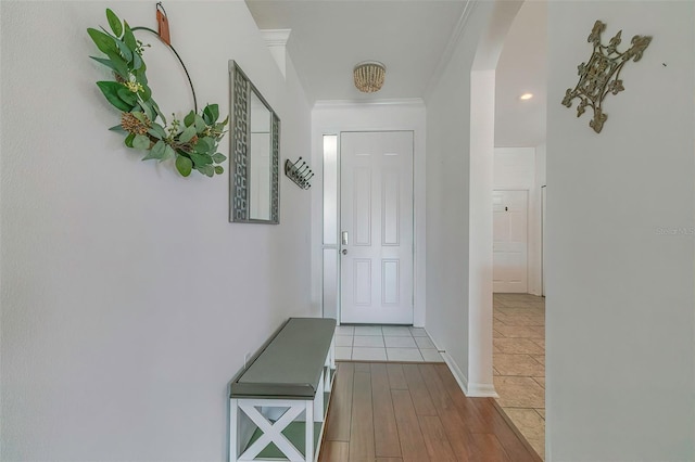 doorway to outside with light hardwood / wood-style flooring and crown molding