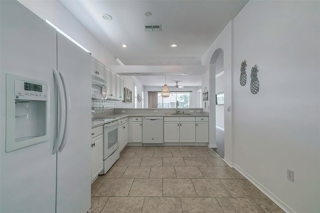 kitchen featuring backsplash, white appliances, white cabinetry, and sink