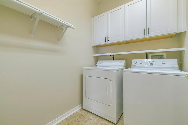 washroom with cabinets and washer and dryer