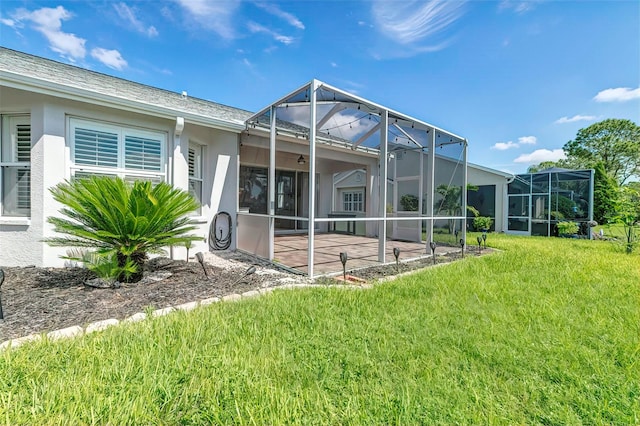 back of property with a lawn, a lanai, and a patio area