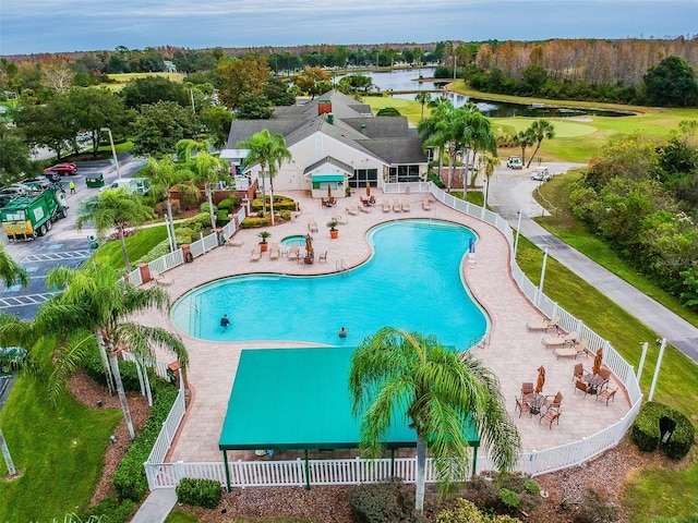 view of pool featuring a water view and a patio