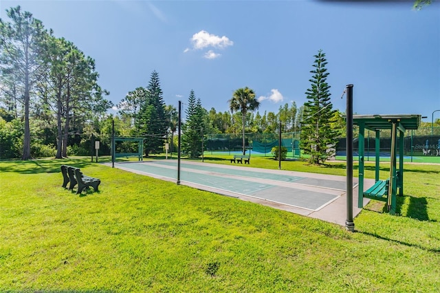 view of sport court featuring tennis court and a yard